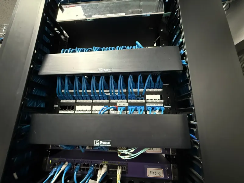Rack con paneles de parcheo etiquetados, organizadores Panduit y enlace de fibra óptica